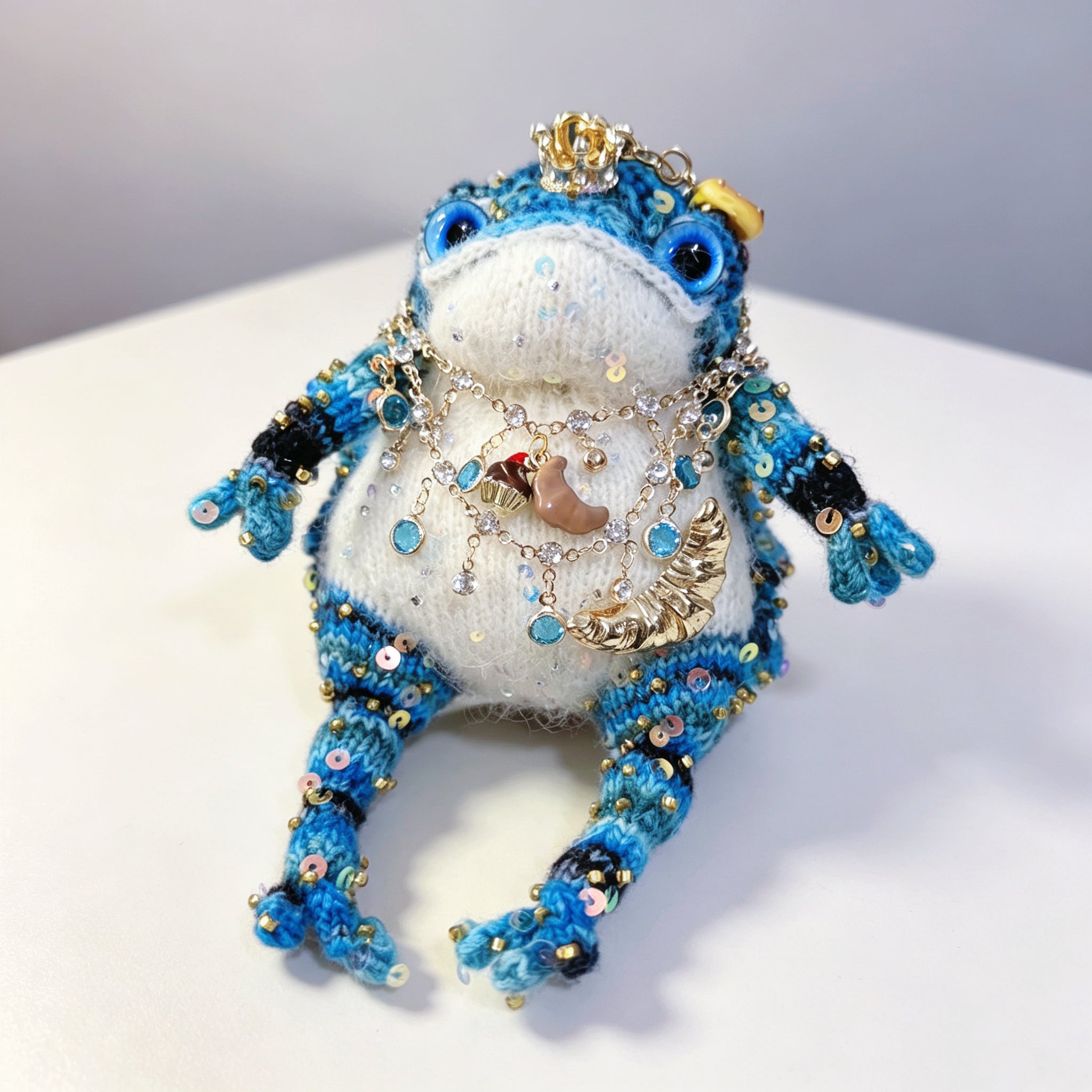 The Baker of Sweets – Hand-Knitted Royal Toad with Gold Crown, Blue Glass Eyes, Dessert Pendant Necklace (Croissant, Donut, Macaron, Cupcake, Baguette) &amp; Sequin-Studded Blue Gradient Body, Complete with Mini Bakery Prop Set | The Third Space