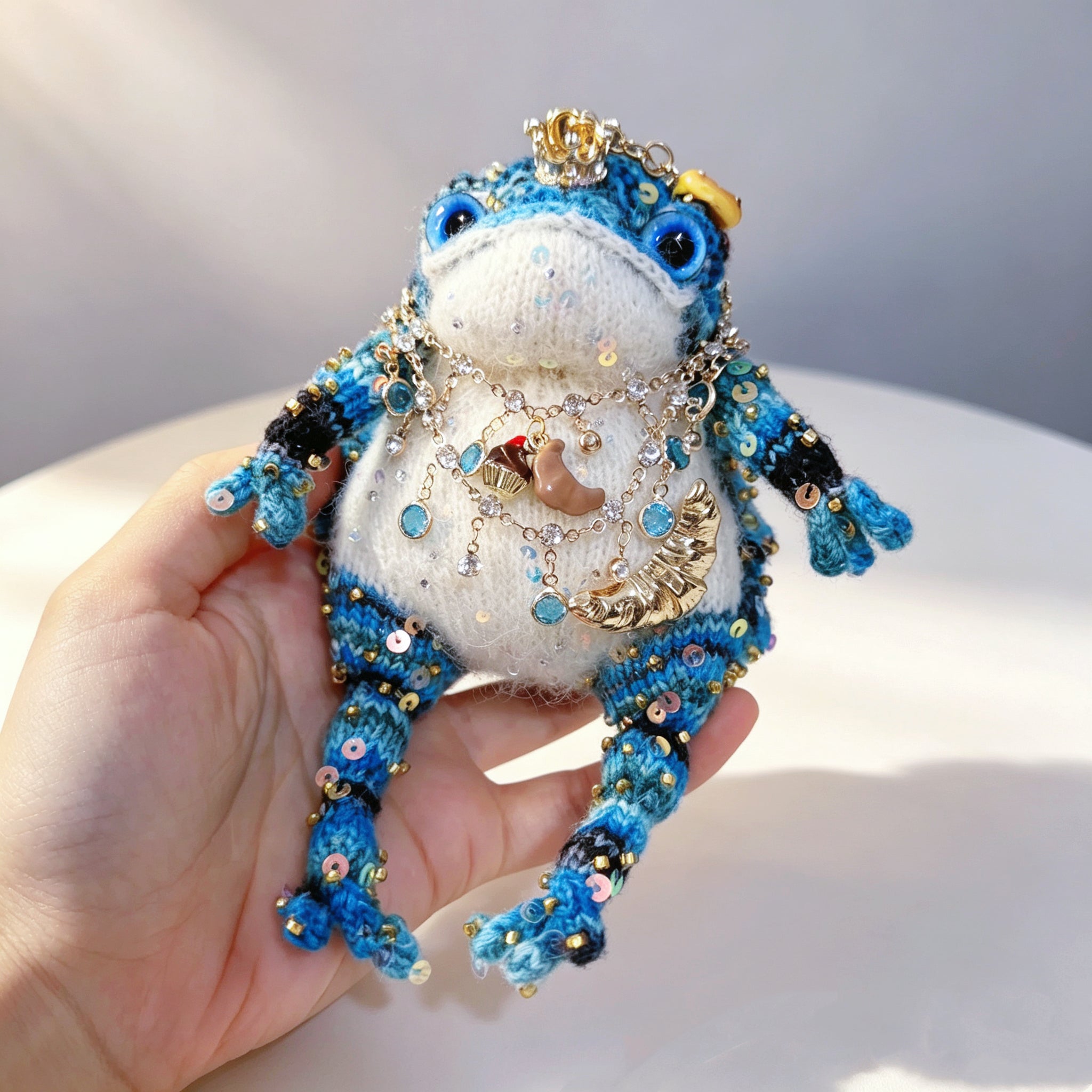 The Baker of Sweets – Hand-Knitted Royal Toad with Gold Crown, Blue Glass Eyes, Dessert Pendant Necklace (Croissant, Donut, Macaron, Cupcake, Baguette) &amp; Sequin-Studded Blue Gradient Body, Complete with Mini Bakery Prop Set | The Third Space