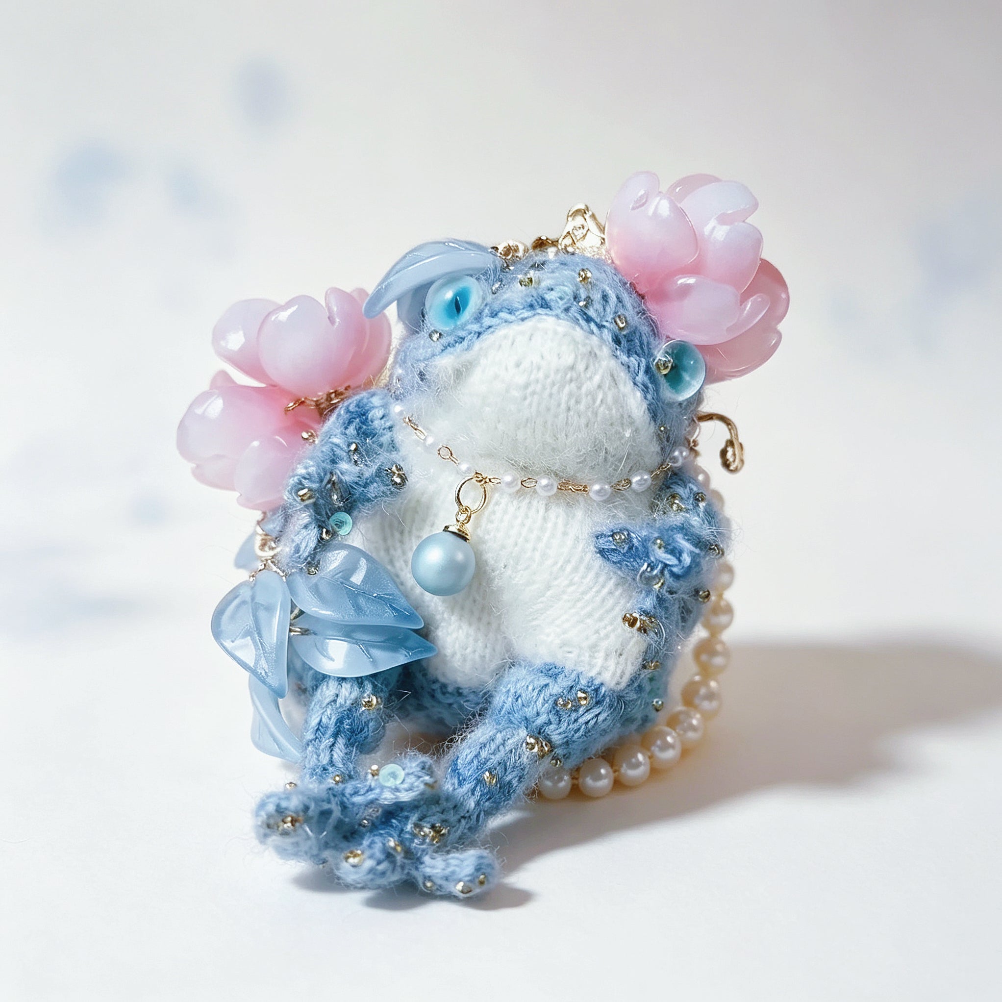 The Flower-Crowned Forest Prince – Hand-Knitted Miniature Toad Charm with Gold Crown, Blue Glass Eyes, Pink Blossoms, Pearl Necklace &amp; Sequin-Toed Limbs | The Third Space